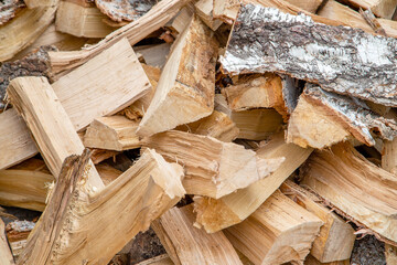 A pile of birch firewood. Dry logs close-up