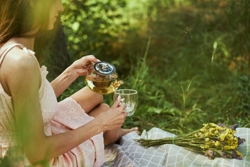 Relaxed woman enjoying delicious beverage in the forest