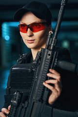Pensive shooter in protective eyewear holding a weapon