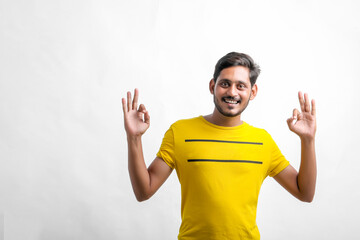 Fototapeta premium Young indian man showing direction with hand over white background.
