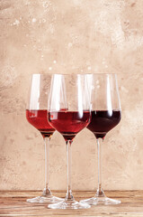 Rose wine glasses on the beige table. Rosado, rosato or blush wine tasting concept, negative space