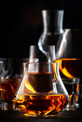 Strong alcoholic drinks, spirits and distillates iset in glasses: cognac, scotch, whiskey and other. Black bar counter background