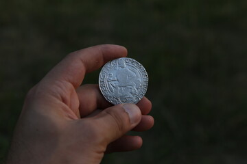 Silver medieval coin in hand