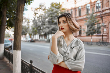 cute blonde girl with red lips outdoors walk near the building
