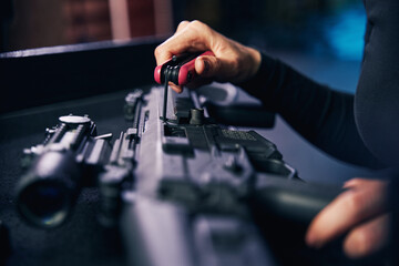 Caucasian female hands assembling an assault rifle