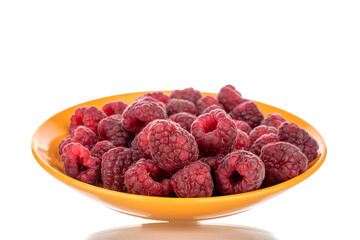 Several berries of ripe red raspberries on a yellow ceramic saucer, close-up, isolated on white.