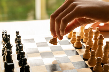 Hand moving a chess piece across the board. Close up with shallow depth of field