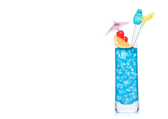 Blue lagoon cocktail highball glass with stirrers and orange slice with sweet cherry and umbrella on white. Vodka and blue curacao liqueur mix.