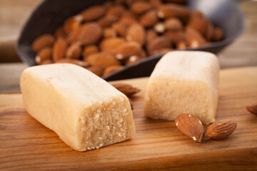 Marzipan bars and almonds on chopping board - 451149788
