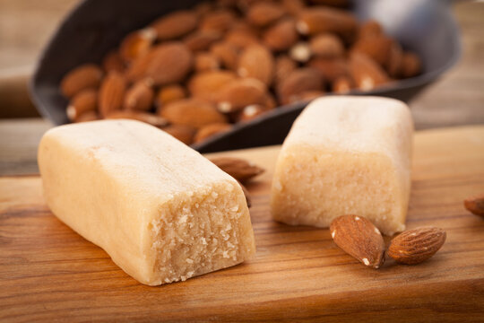 Marzipan bars and almonds on chopping board