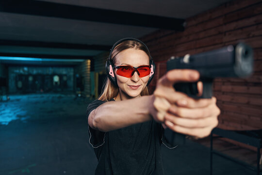 Young woman concentrated on shooting at a target