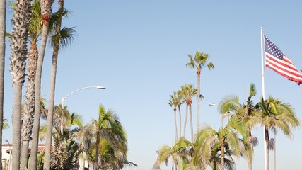 Palms and american flag, Los Angeles, California USA. Summertime aesthetic of Santa Monica Venice Beach. Star-Spangled Banner, Stars and Stripes. Atmosphere of patriotism in Hollywood. LA vibes.