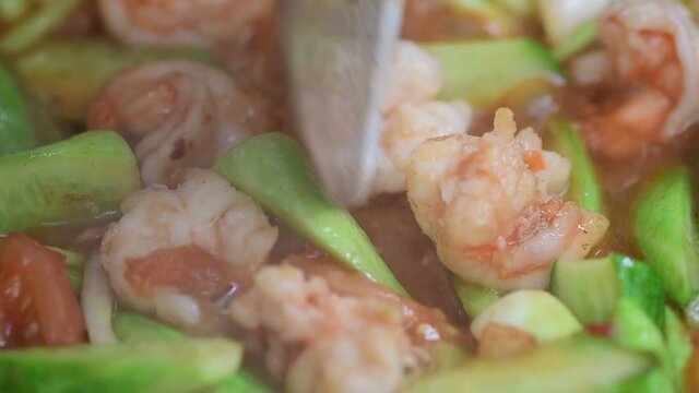 Shrimp and cucumber simmering in sweet and sour tomato sauce