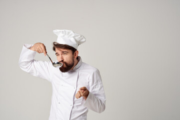 man in chef's uniform tasting food professional cooking work