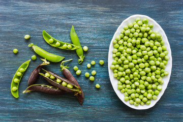 Peeled green peas in a white bowl. Kitchen scene.