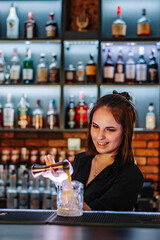 Portrait of young attractive woman bartender Making Cocktail in bar