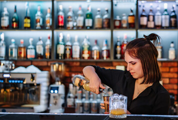 Portrait of young attractive woman bartender Making Cocktail in bar