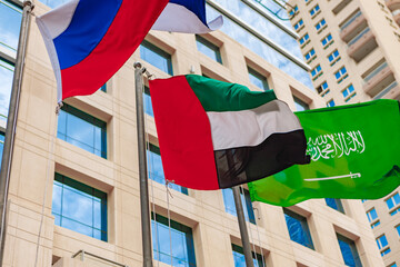 United Arab Emirates and Russia flag waving against building