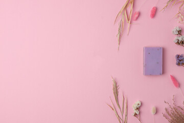 Soap and flower on pink background. Flat lay, copy space.