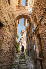 A young man walk along the beautiful streets of Spello, Umbria