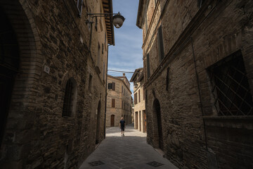 A young man walk along the streets of Bevagna, Umbria