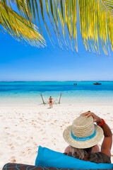 Fototapeta na wymiar femme au chapeau de Paille sur plage paradisiaque 
