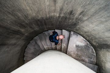 View from the bottom of a young man walking on a staircase in a tunnel