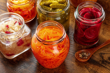 Fototapeta na wymiar Fermented food. Canned vegetables. Pickled carrot, beet, sauerkraut and other organic preserves in mason jars. Healthy vegan products on a wooden table