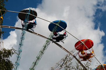 ferris wheel in the park on the background of a blue sky with clouds