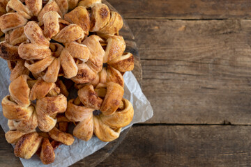 Apple rings in dough. Sweet homemade cakes. Puff pastry pies with apple filling. Simple pie on a wooden background. Copy space. Food for dessert. Rustic. Cinnamon rolls.
