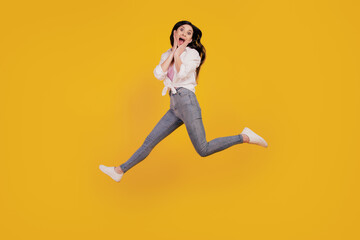 Fototapeta na wymiar Portrait of funky amazed girl jump plams cheeks run on yellow background