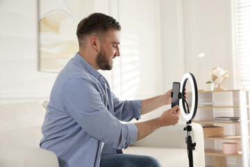 Blogger preparing for video recording at home. Using ring lamp and smartphone