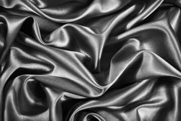 Black white silk satin background. Wavy soft folds on shiny fabric. Silver luxury background for design. Web banner. Holiday, anniversary, valentine, birthday, christmas.