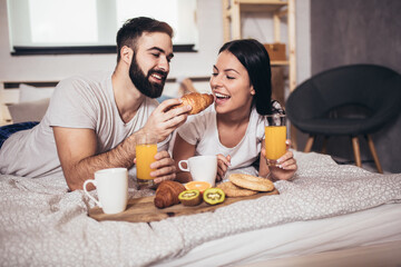 Romantic happy couple having breakfast in bed