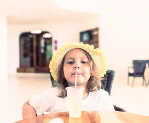 child drinks lemonade through a straw