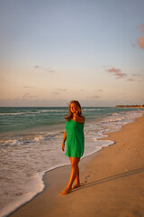 Girl walks along the beach in a dress