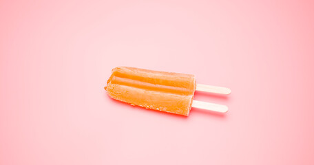 Close-up detail Top view, Ice cream orange popsicle stick melting isolated on the floor pink background.