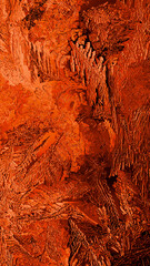 Fantasy ice crystals. Red winter mobile phone wallpaper. Drawing of frost on window glass. A pattern of leaves and stems of magical plants. Vertical abstract mystical and passionate background. Macro