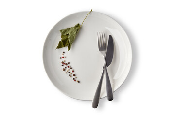 White ceramic plate decorated with peppercorns and dried currant leaves