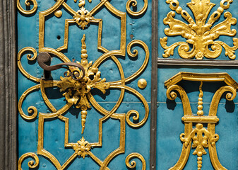 fragment of blue and golden old carved metal gate