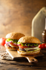 Traditional homemade cheeseburgers with lettuce and onion