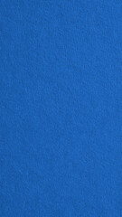 The surface of blue cardboard. Paperboard mobile phone wallpaper. Paper texture with cellulose fibers. Background with bright expressive tint. Textured backdrop. Top-down. Macro