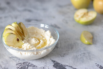 cottage cheese dessert with apples and syrup on a light background