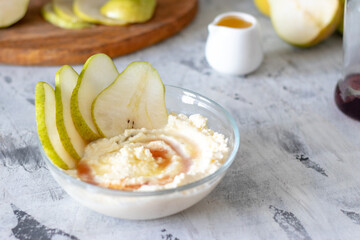 cottage cheese poured with syrup with slices of fresh pear