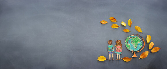 Back to school concept. Top view banner of kids next to globe with autumn dry leaves over classroom...
