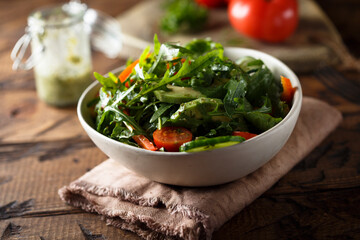 Healthy arugula salad with tomato and cucumber