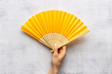 Hand fan made of bamboo and paper in female hand