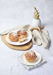 luxury home made chilled vanilla cream puff pastry choux with sugar powder on wood plate and cloth in white marble background dessert halal menu
