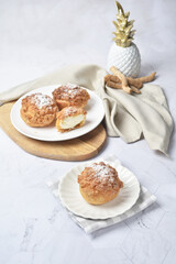 luxury home made chilled vanilla cream puff pastry choux with sugar powder on wood plate and cloth in white marble background dessert halal menu