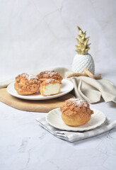 luxury home made chilled vanilla cream puff pastry choux with sugar powder on wood plate and cloth in white marble background dessert halal menu